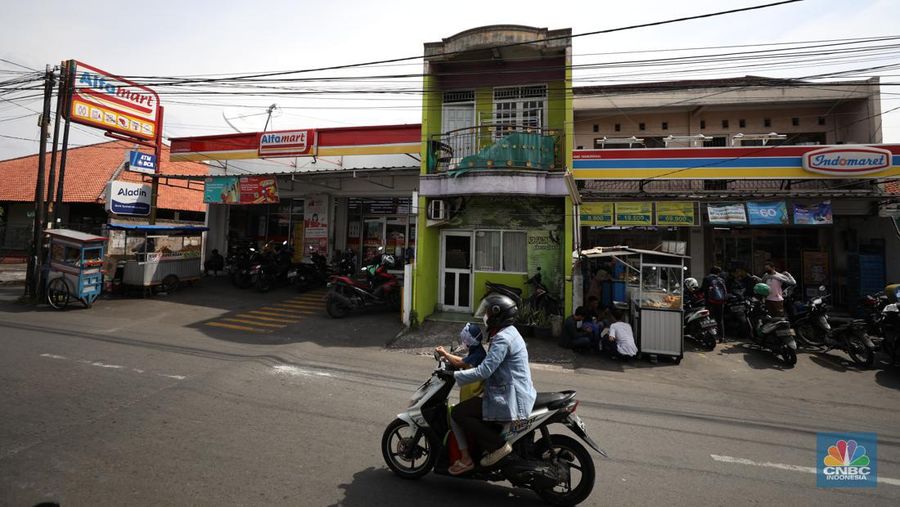 Sejumlah warga melewati toko Indomaret dan Alfamart yang berlokasi di Sukabumi Utara, Jakarta Barat, Kamis (27/1/2022). Indomaret dan Alfamart mungkin terlihat selalu berdekatan yang memiliki banyak persamaan. Namun, keduanya mengakui bahwa mereka memiliki keunggulannya masing-masing. Ada yang mengusung keunggulan dari segi harga lebih murah, kapasitas toko lebih luas, pelayanan lebih ramah atau kenyamanan suasana. Pantauan dilokasi Indomaret dan Alfamart berdekatan dan bersampingan berlada di berbagai lokasi contohnya, Petukangan Utara, Kreo, Duri Kosambi dan Kebon Jeruk. (CNBC Indonesia/Tri Susilo)