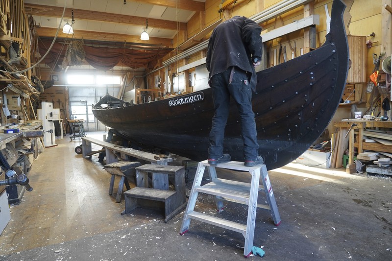 A man repairs a 10-meter wooden row boat, built in the Nordic clinker boat tradition, at the Viking Ship Museum's boatyard. Roskilde, Denmark, Monday, Jan. 17, 2022.  For thousands of years, wooden sail boats, best known for having been in use during the Viking-era, allowed the peoples of northern Europe to spread trade, influence and -- in some cases war — across the seas and rivers. In December, UNESCO, the U.N.’s culture agency, added the “clinker’ boat traditions to its list of “Intangible Cultural Heritage,” the result of the first joint nomination from the whole Nordic region. (AP Photo/James Brooks)