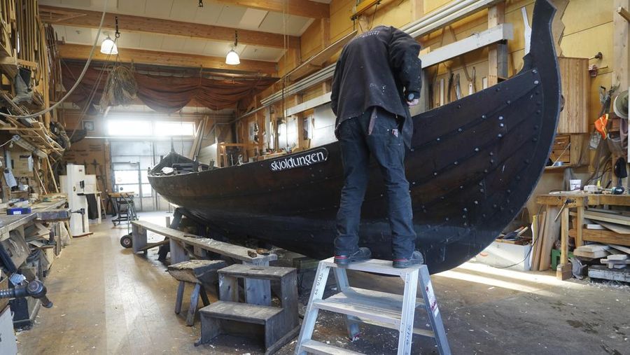 A man repairs a 10-meter wooden row boat, built in the Nordic clinker boat tradition, at the Viking Ship Museum's boatyard. Roskilde, Denmark, Monday, Jan. 17, 2022.  For thousands of years, wooden sail boats, best known for having been in use during the Viking-era, allowed the peoples of northern Europe to spread trade, influence and -- in some cases war — across the seas and rivers. In December, UNESCO, the U.N.’s culture agency, added the “clinker’ boat traditions to its list of “Intangible Cultural Heritage,” the result of the first joint nomination from the whole Nordic region. (AP Photo/James Brooks)