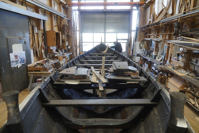 Kapal dagang Viking Denmark UNESCO A man repairs a 10-meter wooden row boat, built in the Nordic clinker boat tradition, at the Viking Ship Museum's boatyard. Roskilde, Denmark, Monday, Jan. 17, 2022. For thousands of years, wooden sail boats, best known for having been in use during the Viking-era, allowed the peoples of northern Europe to spread trade, influence and -- in some cases war — across the seas and rivers. In December, UNESCO, the U.N.’s culture agency, added the “clinker’ boat traditions to its list of “Intangible Cultural Heritage,” the result of the first joint nomination from the whole Nordic region. (AP Photo/James Brooks)