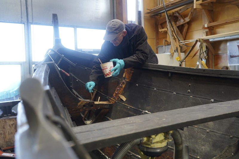Kapal dagang Viking Denmark UNESCO A man repairs a 10-meter wooden row boat, built in the Nordic clinker boat tradition, at the Viking Ship Museum's boatyard. Roskilde, Denmark, Monday, Jan. 17, 2022. For thousands of years, wooden sail boats, best known for having been in use during the Viking-era, allowed the peoples of northern Europe to spread trade, influence and -- in some cases war — across the seas and rivers. In December, UNESCO, the U.N.’s culture agency, added the “clinker’ boat traditions to its list of “Intangible Cultural Heritage,” the result of the first joint nomination from the whole Nordic region. (AP Photo/James Brooks)