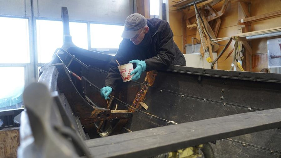 A man repairs a 10-meter wooden row boat, built in the Nordic clinker boat tradition, at the Viking Ship Museum's boatyard. Roskilde, Denmark, Monday, Jan. 17, 2022.  For thousands of years, wooden sail boats, best known for having been in use during the Viking-era, allowed the peoples of northern Europe to spread trade, influence and -- in some cases war — across the seas and rivers. In December, UNESCO, the U.N.’s culture agency, added the “clinker’ boat traditions to its list of “Intangible Cultural Heritage,” the result of the first joint nomination from the whole Nordic region. (AP Photo/James Brooks)