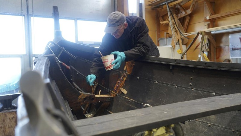 A man repairs a 10-meter wooden row boat, built in the Nordic clinker boat tradition, at the Viking Ship Museum's boatyard. Roskilde, Denmark, Monday, Jan. 17, 2022.  For thousands of years, wooden sail boats, best known for having been in use during the Viking-era, allowed the peoples of northern Europe to spread trade, influence and -- in some cases war — across the seas and rivers. In December, UNESCO, the U.N.’s culture agency, added the “clinker’ boat traditions to its list of “Intangible Cultural Heritage,” the result of the first joint nomination from the whole Nordic region. (AP Photo/James Brooks)