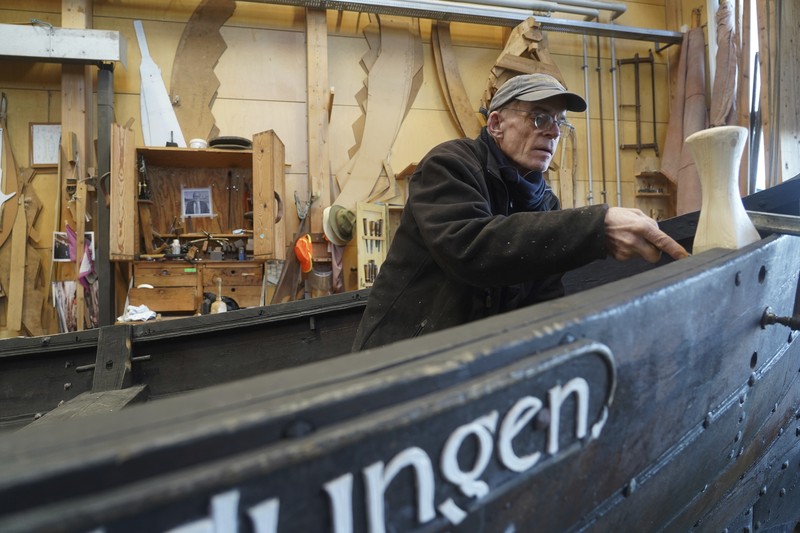 Kapal dagang Viking Denmark UNESCO A man repairs a 10-meter wooden row boat, built in the Nordic clinker boat tradition, at the Viking Ship Museum's boatyard. Roskilde, Denmark, Monday, Jan. 17, 2022. For thousands of years, wooden sail boats, best known for having been in use during the Viking-era, allowed the peoples of northern Europe to spread trade, influence and -- in some cases war — across the seas and rivers. In December, UNESCO, the U.N.’s culture agency, added the “clinker’ boat traditions to its list of “Intangible Cultural Heritage,” the result of the first joint nomination from the whole Nordic region. (AP Photo/James Brooks)