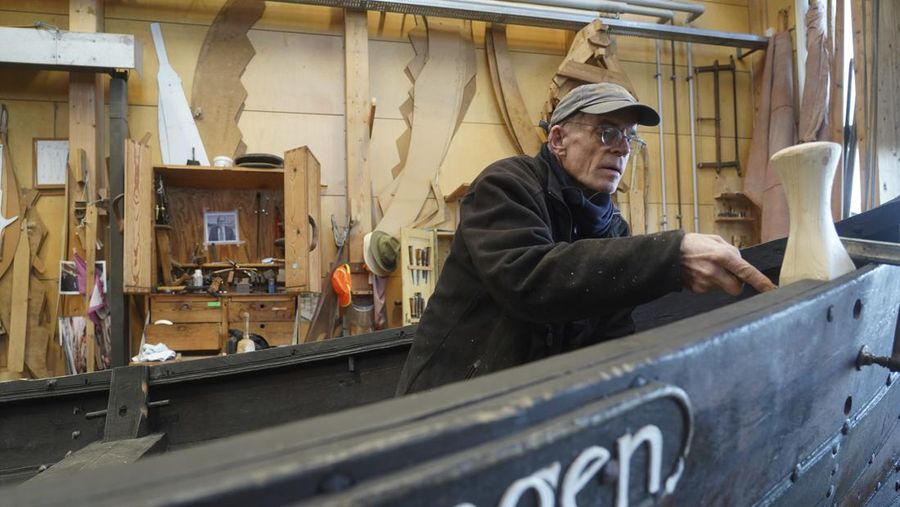 A man repairs a 10-meter wooden row boat, built in the Nordic clinker boat tradition, at the Viking Ship Museum's boatyard. Roskilde, Denmark, Monday, Jan. 17, 2022.  For thousands of years, wooden sail boats, best known for having been in use during the Viking-era, allowed the peoples of northern Europe to spread trade, influence and -- in some cases war — across the seas and rivers. In December, UNESCO, the U.N.’s culture agency, added the “clinker’ boat traditions to its list of “Intangible Cultural Heritage,” the result of the first joint nomination from the whole Nordic region. (AP Photo/James Brooks)