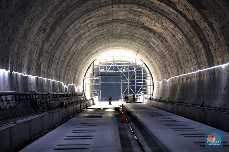 Pekerja Mengerjakan Proyek Tunnel #1 Kereta Cepat Jakarta Bandung Sepanjang 1.885 meter atau 1,8 kilometer yang berlokasi di Jalan Tol Jakarta-Cikampek KM 5+500, Kamis, (27/1/2022). Tunnel 1 merupakan terowongan dengan dua lintasan kereta cepat yang berlokasi di area Halim dan berjarak 2.5 kilometer dari Stasiun Kereta Cepat.

Tunnel 1 dirancang sepanjang 1.885 meter dan dibangun dengan metode Tunnel Boring Machine (TBM). Terowongan ini melintang menembus bagian bawah Jalan Tol Jakarta-Cikampek.

Pembangunan proyek Tunnel 1 ini dilakukan menggunakan mesin bor atau Tunnel Boring Machine (TBM). TBM merupakan mesin bor pembuat terowongan yang didatangkan langsung dari negeri China, untuk membuat struktur Tunnel 1 Kereta Cepat Jakarta Bandung. TBM yang digunakan memiliki diameter 13,23 meter dengan panjang 102,3 meter, berat 2.600 ton dan menjadi mesin bor TBM terbesar se-Asia Tenggara.

TBM kereta cepat ini beroperasi menggali struktur tunnel 1 dengan rata-rata 113 meter per bulan. Saat beroperasi maksimum, TBM kereta cepat mampu menggali hingga 322 meter dalam satu bulan.

Ukuran TBM yang sangat besar ini diganjar Museum Rekor Dunia Indonesia (MURI) sebagai mesin bor terbesar penggali terowongan yang ada di Indonesia. Dari 5 tunnel yang telah dibangun untuk proyek KCJB, hanya Tunnel 1 Halim yang dibangun menggunakan mesin bor TBM. (CNBC Indonesia/ Muhammad Sabki)