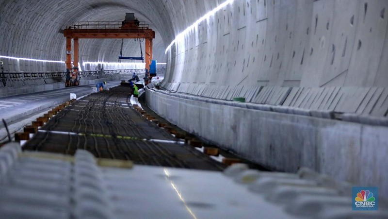 Pekerja Mengerjakan Proyek Tunnel #1 Kereta Cepat Jakarta Bandung Sepanjang 1.885 meter atau 1,8 kilometer yang berlokasi di Jalan Tol Jakarta-Cikampek KM 5+500, Kamis, (27/1/2022). Tunnel 1 merupakan terowongan dengan dua lintasan kereta cepat yang berlokasi di area Halim dan berjarak 2.5 kilometer dari Stasiun Kereta Cepat.

Tunnel 1 dirancang sepanjang 1.885 meter dan dibangun dengan metode Tunnel Boring Machine (TBM). Terowongan ini melintang menembus bagian bawah Jalan Tol Jakarta-Cikampek.

Pembangunan proyek Tunnel 1 ini dilakukan menggunakan mesin bor atau Tunnel Boring Machine (TBM). TBM merupakan mesin bor pembuat terowongan yang didatangkan langsung dari negeri China, untuk membuat struktur Tunnel 1 Kereta Cepat Jakarta Bandung. TBM yang digunakan memiliki diameter 13,23 meter dengan panjang 102,3 meter, berat 2.600 ton dan menjadi mesin bor TBM terbesar se-Asia Tenggara.

TBM kereta cepat ini beroperasi menggali struktur tunnel 1 dengan rata-rata 113 meter per bulan. Saat beroperasi maksimum, TBM kereta cepat mampu menggali hingga 322 meter dalam satu bulan.

Ukuran TBM yang sangat besar ini diganjar Museum Rekor Dunia Indonesia (MURI) sebagai mesin bor terbesar penggali terowongan yang ada di Indonesia. Dari 5 tunnel yang telah dibangun untuk proyek KCJB, hanya Tunnel 1 Halim yang dibangun menggunakan mesin bor TBM. (CNBC Indonesia/ Muhammad Sabki)