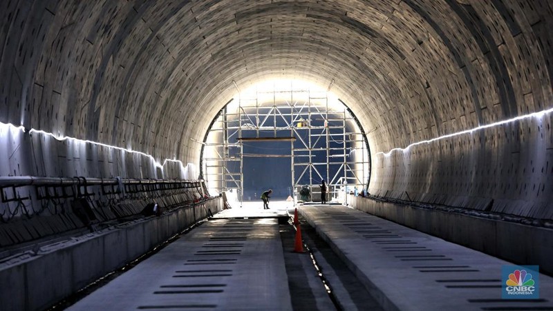 Pekerja Mengerjakan Proyek Tunnel #1 Kereta Cepat Jakarta Bandung Sepanjang 1.885 meter atau 1,8 kilometer yang berlokasi di Jalan Tol Jakarta-Cikampek KM 5+500, Kamis, (27/1/2022). Tunnel 1 merupakan terowongan dengan dua lintasan kereta cepat yang berlokasi di area Halim dan berjarak 2.5 kilometer dari Stasiun Kereta Cepat.

Tunnel 1 dirancang sepanjang 1.885 meter dan dibangun dengan metode Tunnel Boring Machine (TBM). Terowongan ini melintang menembus bagian bawah Jalan Tol Jakarta-Cikampek.

Pembangunan proyek Tunnel 1 ini dilakukan menggunakan mesin bor atau Tunnel Boring Machine (TBM). TBM merupakan mesin bor pembuat terowongan yang didatangkan langsung dari negeri China, untuk membuat struktur Tunnel 1 Kereta Cepat Jakarta Bandung. TBM yang digunakan memiliki diameter 13,23 meter dengan panjang 102,3 meter, berat 2.600 ton dan menjadi mesin bor TBM terbesar se-Asia Tenggara.

TBM kereta cepat ini beroperasi menggali struktur tunnel 1 dengan rata-rata 113 meter per bulan. Saat beroperasi maksimum, TBM kereta cepat mampu menggali hingga 322 meter dalam satu bulan.

Ukuran TBM yang sangat besar ini diganjar Museum Rekor Dunia Indonesia (MURI) sebagai mesin bor terbesar penggali terowongan yang ada di Indonesia. Dari 5 tunnel yang telah dibangun untuk proyek KCJB, hanya Tunnel 1 Halim yang dibangun menggunakan mesin bor TBM. (CNBC Indonesia/ Muhammad Sabki)