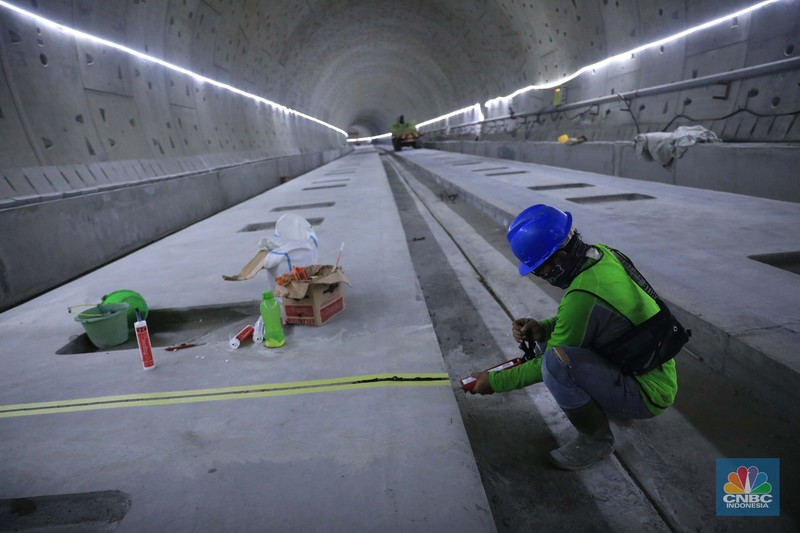 Pekerja Mengerjakan Proyek Tunnel #1 Kereta Cepat Jakarta Bandung Sepanjang 1.885 meter atau 1,8 kilometer yang berlokasi di Jalan Tol Jakarta-Cikampek KM 5+500, Kamis, (27/1/2022). Tunnel 1 merupakan terowongan dengan dua lintasan kereta cepat yang berlokasi di area Halim dan berjarak 2.5 kilometer dari Stasiun Kereta Cepat.

Tunnel 1 dirancang sepanjang 1.885 meter dan dibangun dengan metode Tunnel Boring Machine (TBM). Terowongan ini melintang menembus bagian bawah Jalan Tol Jakarta-Cikampek.

Pembangunan proyek Tunnel 1 ini dilakukan menggunakan mesin bor atau Tunnel Boring Machine (TBM). TBM merupakan mesin bor pembuat terowongan yang didatangkan langsung dari negeri China, untuk membuat struktur Tunnel 1 Kereta Cepat Jakarta Bandung. TBM yang digunakan memiliki diameter 13,23 meter dengan panjang 102,3 meter, berat 2.600 ton dan menjadi mesin bor TBM terbesar se-Asia Tenggara.

TBM kereta cepat ini beroperasi menggali struktur tunnel 1 dengan rata-rata 113 meter per bulan. Saat beroperasi maksimum, TBM kereta cepat mampu menggali hingga 322 meter dalam satu bulan.

Ukuran TBM yang sangat besar ini diganjar Museum Rekor Dunia Indonesia (MURI) sebagai mesin bor terbesar penggali terowongan yang ada di Indonesia. Dari 5 tunnel yang telah dibangun untuk proyek KCJB, hanya Tunnel 1 Halim yang dibangun menggunakan mesin bor TBM. (CNBC Indonesia/ Muhammad Sabki)