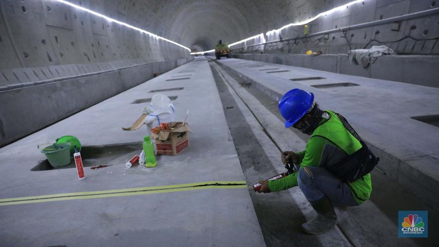 Pekerja Mengerjakan Proyek Tunnel #1 Kereta Cepat Jakarta Bandung Sepanjang 1.885 meter atau 1,8 kilometer yang berlokasi di Jalan Tol Jakarta-Cikampek KM 5+500, Kamis, (27/1/2022). Tunnel 1 merupakan terowongan dengan dua lintasan kereta cepat yang berlokasi di area Halim dan berjarak 2.5 kilometer dari Stasiun Kereta Cepat.

Tunnel 1 dirancang sepanjang 1.885 meter dan dibangun dengan metode Tunnel Boring Machine (TBM). Terowongan ini melintang menembus bagian bawah Jalan Tol Jakarta-Cikampek.

Pembangunan proyek Tunnel 1 ini dilakukan menggunakan mesin bor atau Tunnel Boring Machine (TBM). TBM merupakan mesin bor pembuat terowongan yang didatangkan langsung dari negeri China, untuk membuat struktur Tunnel 1 Kereta Cepat Jakarta Bandung. TBM yang digunakan memiliki diameter 13,23 meter dengan panjang 102,3 meter, berat 2.600 ton dan menjadi mesin bor TBM terbesar se-Asia Tenggara.

TBM kereta cepat ini beroperasi menggali struktur tunnel 1 dengan rata-rata 113 meter per bulan. Saat beroperasi maksimum, TBM kereta cepat mampu menggali hingga 322 meter dalam satu bulan.

Ukuran TBM yang sangat besar ini diganjar Museum Rekor Dunia Indonesia (MURI) sebagai mesin bor terbesar penggali terowongan yang ada di Indonesia. Dari 5 tunnel yang telah dibangun untuk proyek KCJB, hanya Tunnel 1 Halim yang dibangun menggunakan mesin bor TBM. (CNBC Indonesia/ Muhammad Sabki)