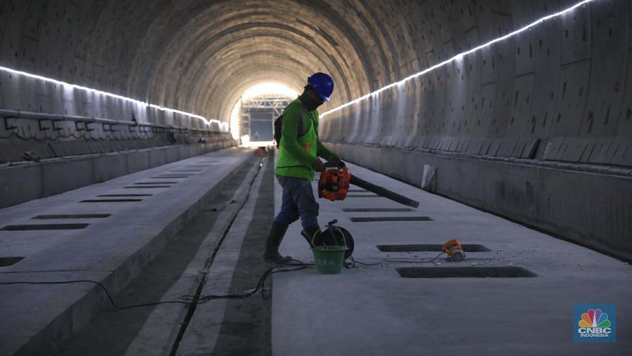 Pekerja Mengerjakan Proyek Tunnel #1 Kereta Cepat Jakarta Bandung Sepanjang 1.885 meter atau 1,8 kilometer yang berlokasi di Jalan Tol Jakarta-Cikampek KM 5+500, Kamis, (27/1/2022). Tunnel 1 merupakan terowongan dengan dua lintasan kereta cepat yang berlokasi di area Halim dan berjarak 2.5 kilometer dari Stasiun Kereta Cepat.

Tunnel 1 dirancang sepanjang 1.885 meter dan dibangun dengan metode Tunnel Boring Machine (TBM). Terowongan ini melintang menembus bagian bawah Jalan Tol Jakarta-Cikampek.

Pembangunan proyek Tunnel 1 ini dilakukan menggunakan mesin bor atau Tunnel Boring Machine (TBM). TBM merupakan mesin bor pembuat terowongan yang didatangkan langsung dari negeri China, untuk membuat struktur Tunnel 1 Kereta Cepat Jakarta Bandung. TBM yang digunakan memiliki diameter 13,23 meter dengan panjang 102,3 meter, berat 2.600 ton dan menjadi mesin bor TBM terbesar se-Asia Tenggara.

TBM kereta cepat ini beroperasi menggali struktur tunnel 1 dengan rata-rata 113 meter per bulan. Saat beroperasi maksimum, TBM kereta cepat mampu menggali hingga 322 meter dalam satu bulan.

Ukuran TBM yang sangat besar ini diganjar Museum Rekor Dunia Indonesia (MURI) sebagai mesin bor terbesar penggali terowongan yang ada di Indonesia. Dari 5 tunnel yang telah dibangun untuk proyek KCJB, hanya Tunnel 1 Halim yang dibangun menggunakan mesin bor TBM. (CNBC Indonesia/ Muhammad Sabki)