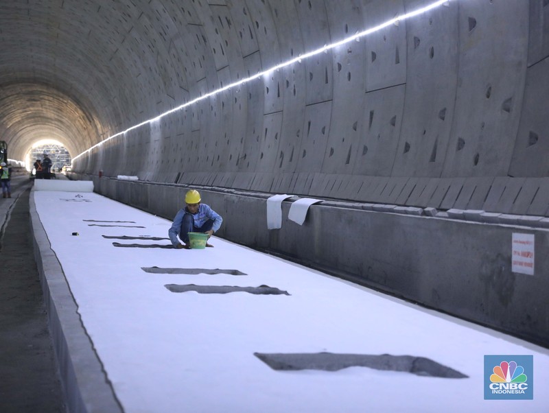 Pekerja Mengerjakan Proyek Tunnel #1 Kereta Cepat Jakarta Bandung Sepanjang 1.885 meter atau 1,8 kilometer yang berlokasi di Jalan Tol Jakarta-Cikampek KM 5+500, Kamis, (27/1/2022). Tunnel 1 merupakan terowongan dengan dua lintasan kereta cepat yang berlokasi di area Halim dan berjarak 2.5 kilometer dari Stasiun Kereta Cepat.

Tunnel 1 dirancang sepanjang 1.885 meter dan dibangun dengan metode Tunnel Boring Machine (TBM). Terowongan ini melintang menembus bagian bawah Jalan Tol Jakarta-Cikampek.

Pembangunan proyek Tunnel 1 ini dilakukan menggunakan mesin bor atau Tunnel Boring Machine (TBM). TBM merupakan mesin bor pembuat terowongan yang didatangkan langsung dari negeri China, untuk membuat struktur Tunnel 1 Kereta Cepat Jakarta Bandung. TBM yang digunakan memiliki diameter 13,23 meter dengan panjang 102,3 meter, berat 2.600 ton dan menjadi mesin bor TBM terbesar se-Asia Tenggara.

TBM kereta cepat ini beroperasi menggali struktur tunnel 1 dengan rata-rata 113 meter per bulan. Saat beroperasi maksimum, TBM kereta cepat mampu menggali hingga 322 meter dalam satu bulan.

Ukuran TBM yang sangat besar ini diganjar Museum Rekor Dunia Indonesia (MURI) sebagai mesin bor terbesar penggali terowongan yang ada di Indonesia. Dari 5 tunnel yang telah dibangun untuk proyek KCJB, hanya Tunnel 1 Halim yang dibangun menggunakan mesin bor TBM. (CNBC Indonesia/ Muhammad Sabki)