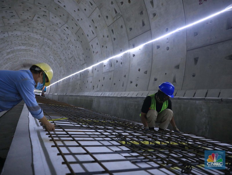 Pekerja Mengerjakan Proyek Tunnel #1 Kereta Cepat Jakarta Bandung Sepanjang 1.885 meter atau 1,8 kilometer yang berlokasi di Jalan Tol Jakarta-Cikampek KM 5+500, Kamis, (27/1/2022). Tunnel 1 merupakan terowongan dengan dua lintasan kereta cepat yang berlokasi di area Halim dan berjarak 2.5 kilometer dari Stasiun Kereta Cepat.

Tunnel 1 dirancang sepanjang 1.885 meter dan dibangun dengan metode Tunnel Boring Machine (TBM). Terowongan ini melintang menembus bagian bawah Jalan Tol Jakarta-Cikampek.

Pembangunan proyek Tunnel 1 ini dilakukan menggunakan mesin bor atau Tunnel Boring Machine (TBM). TBM merupakan mesin bor pembuat terowongan yang didatangkan langsung dari negeri China, untuk membuat struktur Tunnel 1 Kereta Cepat Jakarta Bandung. TBM yang digunakan memiliki diameter 13,23 meter dengan panjang 102,3 meter, berat 2.600 ton dan menjadi mesin bor TBM terbesar se-Asia Tenggara.

TBM kereta cepat ini beroperasi menggali struktur tunnel 1 dengan rata-rata 113 meter per bulan. Saat beroperasi maksimum, TBM kereta cepat mampu menggali hingga 322 meter dalam satu bulan.

Ukuran TBM yang sangat besar ini diganjar Museum Rekor Dunia Indonesia (MURI) sebagai mesin bor terbesar penggali terowongan yang ada di Indonesia. Dari 5 tunnel yang telah dibangun untuk proyek KCJB, hanya Tunnel 1 Halim yang dibangun menggunakan mesin bor TBM. (CNBC Indonesia/ Muhammad Sabki)