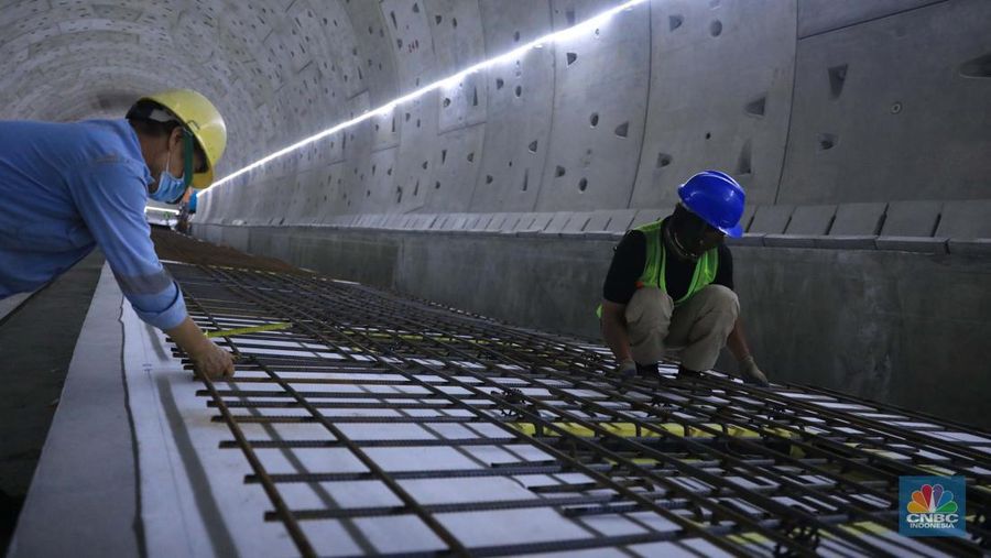 Pekerja Mengerjakan Proyek Tunnel #1 Kereta Cepat Jakarta Bandung Sepanjang 1.885 meter atau 1,8 kilometer yang berlokasi di Jalan Tol Jakarta-Cikampek KM 5+500, Kamis, (27/1/2022). Tunnel 1 merupakan terowongan dengan dua lintasan kereta cepat yang berlokasi di area Halim dan berjarak 2.5 kilometer dari Stasiun Kereta Cepat.

Tunnel 1 dirancang sepanjang 1.885 meter dan dibangun dengan metode Tunnel Boring Machine (TBM). Terowongan ini melintang menembus bagian bawah Jalan Tol Jakarta-Cikampek.

Pembangunan proyek Tunnel 1 ini dilakukan menggunakan mesin bor atau Tunnel Boring Machine (TBM). TBM merupakan mesin bor pembuat terowongan yang didatangkan langsung dari negeri China, untuk membuat struktur Tunnel 1 Kereta Cepat Jakarta Bandung. TBM yang digunakan memiliki diameter 13,23 meter dengan panjang 102,3 meter, berat 2.600 ton dan menjadi mesin bor TBM terbesar se-Asia Tenggara.

TBM kereta cepat ini beroperasi menggali struktur tunnel 1 dengan rata-rata 113 meter per bulan. Saat beroperasi maksimum, TBM kereta cepat mampu menggali hingga 322 meter dalam satu bulan.

Ukuran TBM yang sangat besar ini diganjar Museum Rekor Dunia Indonesia (MURI) sebagai mesin bor terbesar penggali terowongan yang ada di Indonesia. Dari 5 tunnel yang telah dibangun untuk proyek KCJB, hanya Tunnel 1 Halim yang dibangun menggunakan mesin bor TBM. (CNBC Indonesia/ Muhammad Sabki)