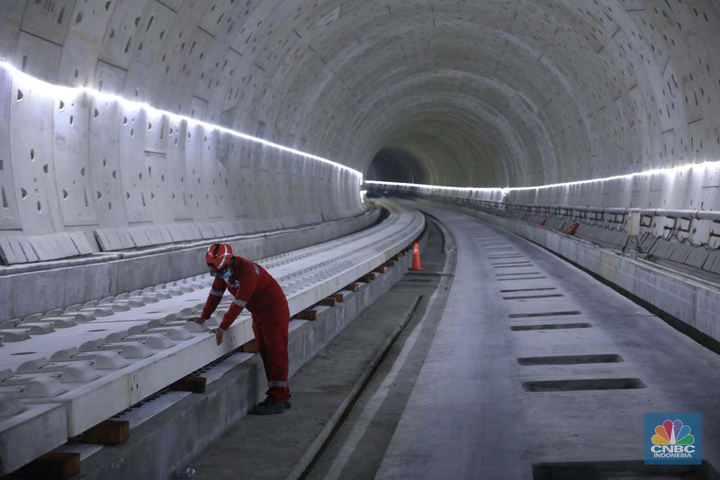 Pekerja Mengerjakan Proyek Tunnel #1 Kereta Cepat Jakarta Bandung Sepanjang 1.885 meter atau 1,8 kilometer yang berlokasi di Jalan Tol Jakarta-Cikampek KM 5+500, Kamis, (27/1/2022). Tunnel 1 merupakan terowongan dengan dua lintasan kereta cepat yang berlokasi di area Halim dan berjarak 2.5 kilometer dari Stasiun Kereta Cepat.

Tunnel 1 dirancang sepanjang 1.885 meter dan dibangun dengan metode Tunnel Boring Machine (TBM). Terowongan ini melintang menembus bagian bawah Jalan Tol Jakarta-Cikampek.

Pembangunan proyek Tunnel 1 ini dilakukan menggunakan mesin bor atau Tunnel Boring Machine (TBM). TBM merupakan mesin bor pembuat terowongan yang didatangkan langsung dari negeri China, untuk membuat struktur Tunnel 1 Kereta Cepat Jakarta Bandung. TBM yang digunakan memiliki diameter 13,23 meter dengan panjang 102,3 meter, berat 2.600 ton dan menjadi mesin bor TBM terbesar se-Asia Tenggara.

TBM kereta cepat ini beroperasi menggali struktur tunnel 1 dengan rata-rata 113 meter per bulan. Saat beroperasi maksimum, TBM kereta cepat mampu menggali hingga 322 meter dalam satu bulan.

Ukuran TBM yang sangat besar ini diganjar Museum Rekor Dunia Indonesia (MURI) sebagai mesin bor terbesar penggali terowongan yang ada di Indonesia. Dari 5 tunnel yang telah dibangun untuk proyek KCJB, hanya Tunnel 1 Halim yang dibangun menggunakan mesin bor TBM. (CNBC Indonesia/ Muhammad Sabki)