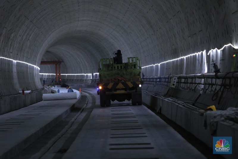 Pekerja Mengerjakan Proyek Tunnel #1 Kereta Cepat Jakarta Bandung Sepanjang 1.885 meter atau 1,8 kilometer yang berlokasi di Jalan Tol Jakarta-Cikampek KM 5+500, Kamis, (27/1/2022). Tunnel 1 merupakan terowongan dengan dua lintasan kereta cepat yang berlokasi di area Halim dan berjarak 2.5 kilometer dari Stasiun Kereta Cepat.

Tunnel 1 dirancang sepanjang 1.885 meter dan dibangun dengan metode Tunnel Boring Machine (TBM). Terowongan ini melintang menembus bagian bawah Jalan Tol Jakarta-Cikampek.

Pembangunan proyek Tunnel 1 ini dilakukan menggunakan mesin bor atau Tunnel Boring Machine (TBM). TBM merupakan mesin bor pembuat terowongan yang didatangkan langsung dari negeri China, untuk membuat struktur Tunnel 1 Kereta Cepat Jakarta Bandung. TBM yang digunakan memiliki diameter 13,23 meter dengan panjang 102,3 meter, berat 2.600 ton dan menjadi mesin bor TBM terbesar se-Asia Tenggara.

TBM kereta cepat ini beroperasi menggali struktur tunnel 1 dengan rata-rata 113 meter per bulan. Saat beroperasi maksimum, TBM kereta cepat mampu menggali hingga 322 meter dalam satu bulan.

Ukuran TBM yang sangat besar ini diganjar Museum Rekor Dunia Indonesia (MURI) sebagai mesin bor terbesar penggali terowongan yang ada di Indonesia. Dari 5 tunnel yang telah dibangun untuk proyek KCJB, hanya Tunnel 1 Halim yang dibangun menggunakan mesin bor TBM. (CNBC Indonesia/ Muhammad Sabki)
