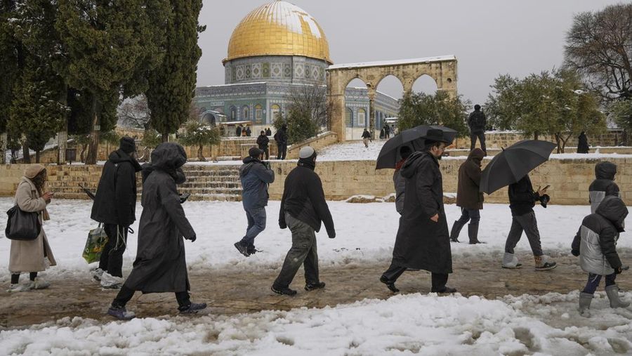 Sekelompok mengunjungi Temple Mount, yang dikenal oleh umat Islam sebagai Tempat Suci di kompleks Masjid Al-Aqsa di Kota Tua Yerusalem, Kamis (27/1/2022). Hujan salju yang jarang melanda sebagian wilayah Israel dan Tepi Barat, menutup sekolah dan bisnis. (AP Photo/Mahmoud Illean)