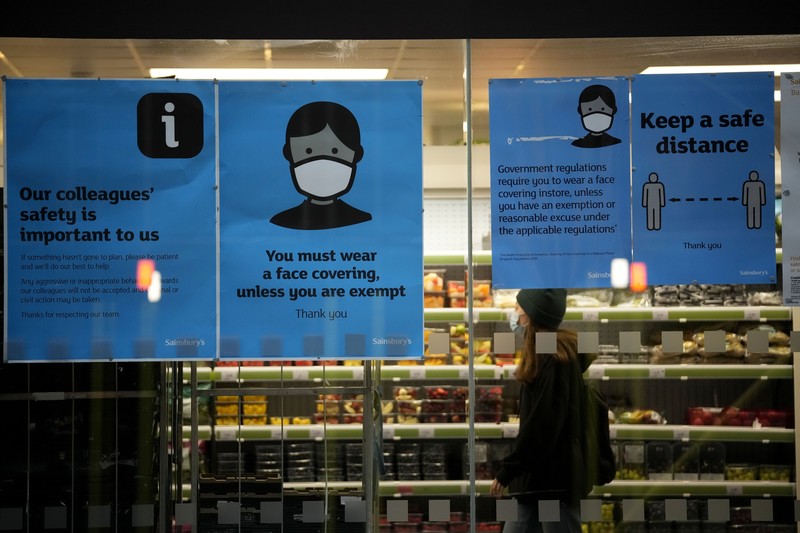 Pelonggaran Pemakaian Masker di Inggris Himbauan pemakaian masker untuk mencegah penyebaran virus corona terpampang di jendela toko supermarket Sainsbury di London, Kamis (27/1/2022). Sebagian besar pembatasan virus corona termasuk wajib wajah Masker dicabut di Inggris pada hari Kamis, setelah pemerintah Inggris mengatakan peluncuran booster vaksinnya berhasil mengurangi penyakit serius dan rawat inap COVID-19. Mulai Kamis, penutup wajah tidak lagi diwajibkan oleh hukum di mana pun di Inggris. (AP Photo/Matt Dunham)
