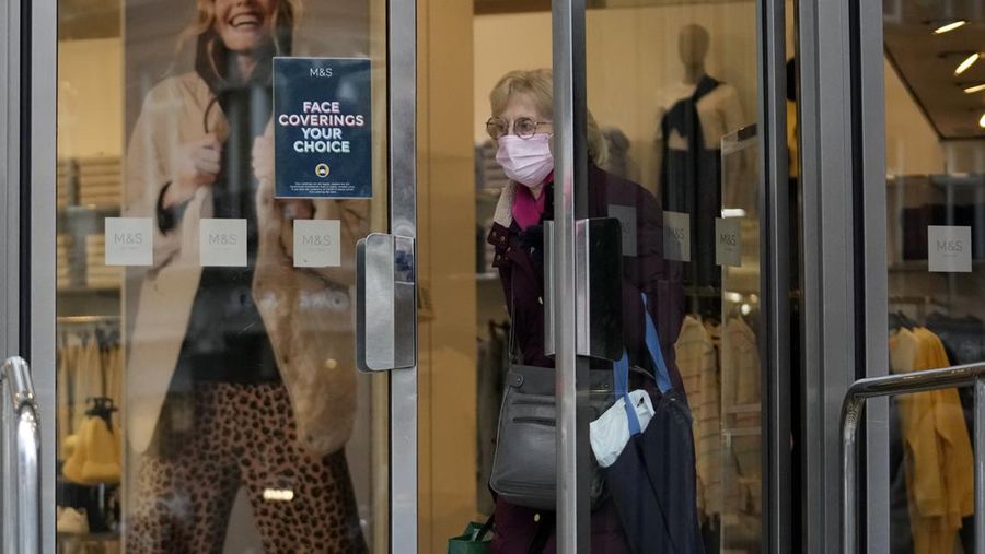 Seorang pembeli yang mengenakan masker wajah untuk mencegah penyebaran virus corona berjalan keluar dari toko Marks and Spencer di Oxford Street, di London, Kamis (27/1/2022). Sebagian besar pembatasan virus corona termasuk wajib wajah Masker dicabut di Inggris pada hari Kamis, setelah pemerintah Inggris mengatakan peluncuran booster vaksinnya berhasil mengurangi penyakit serius dan rawat inap COVID-19. Mulai Kamis, penutup wajah tidak lagi diwajibkan oleh hukum di mana pun di Inggris. (AP Photo/Matt Dunham)