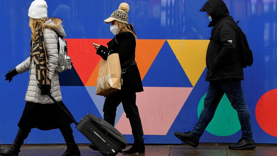 Pembeli yang mengenakan masker berjalan di Oxford Street, saat aturan mengenakan masker dilonggarkan di tengah penyebaran pandemi penyakit coronavirus (COVID-19) di London, Inggris, Kamis (27/1/2022). (REUTERS/Toby Melville)