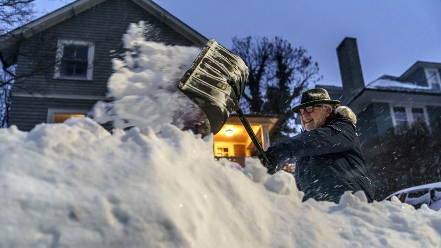 Mike Ratcliffe menyekop salju dari jalan masuk rumahnya di Providence, Rhode Island, Sabtu (29/1/2022). Sebuah nor'easter yang kuat menyapu Pantai Timur pada hari Sabtu, mengancam akan mengubur sebagian dari 10 negara bagian di bawah salju yang dalam dan turun dengan deras disertai banjir pesisir dan angin kencang yang dapat memutus aliran listrik dan membuat orang menggigil di cuaca dingin yang diperkirakan akan menyusul. (AP Photo/David Goldman)