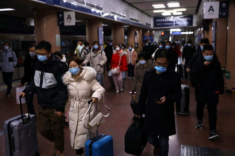 Pelancong mengenakan masker untuk melindungi diri dari COVID-19 mengantre kereta menjelang liburan Tahun Baru Imlek di sebuah stasiun di Guangzhou di Provinsi Guangdong, China selatan, Jumat (28/1/2022).  Warga China bepergian ke kampung halaman mereka untuk Tahun Baru Imlek, hari libur keluarga terbesar di negara itu , meskipun ada permintaan pemerintah untuk tetap di tempat mereka berada saat Beijing mencoba menahan wabah virus corona. (Chinatopix via AP)
