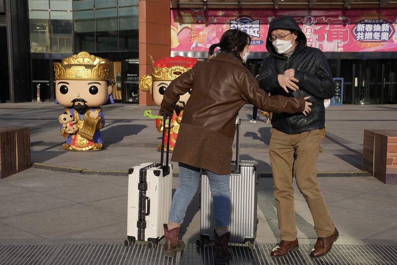 Pelancong mengenakan masker untuk melindungi diri dari COVID-19 mengantre kereta menjelang liburan Tahun Baru Imlek di sebuah stasiun di Guangzhou di Provinsi Guangdong, China selatan, Jumat (28/1/2022).  Warga China bepergian ke kampung halaman mereka untuk Tahun Baru Imlek, hari libur keluarga terbesar di negara itu , meskipun ada permintaan pemerintah untuk tetap di tempat mereka berada saat Beijing mencoba menahan wabah virus corona. (Chinatopix via AP)