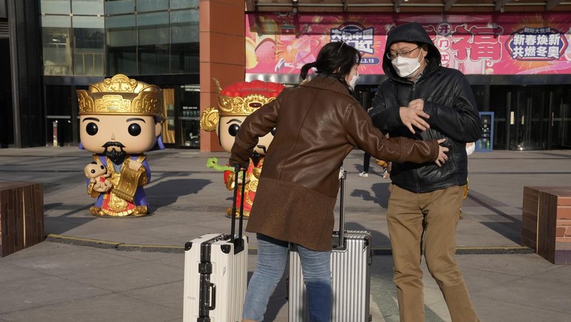 Pelancong mengenakan masker untuk melindungi diri dari COVID-19 mengantre kereta menjelang liburan Tahun Baru Imlek di sebuah stasiun di Guangzhou di Provinsi Guangdong, China selatan, Jumat (28/1/2022).  Warga China bepergian ke kampung halaman mereka untuk Tahun Baru Imlek, hari libur keluarga terbesar di negara itu , meskipun ada permintaan pemerintah untuk tetap di tempat mereka berada saat Beijing mencoba menahan wabah virus corona. (Chinatopix via AP)