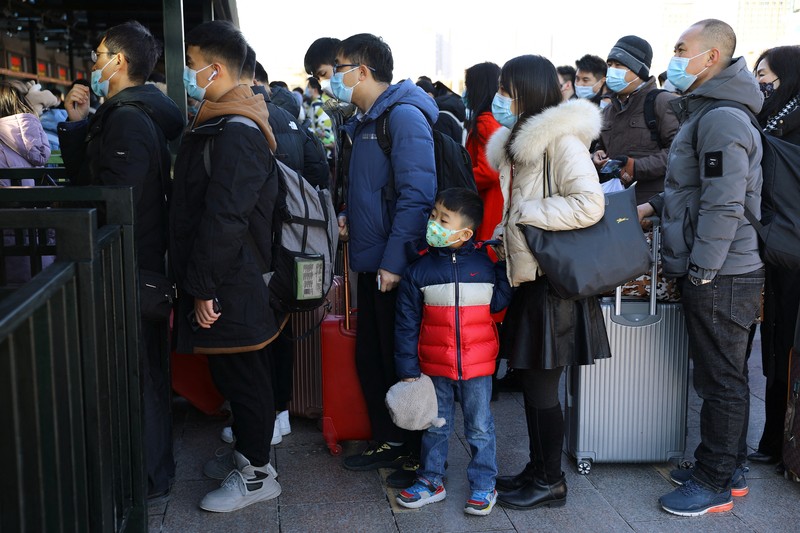 Warga China Mudik Jelang Imlek di Tengah Wabah Covid Pelancong mengenakan masker untuk melindungi diri dari COVID-19 mengantre kereta menjelang liburan Tahun Baru Imlek di sebuah stasiun di Guangzhou di Provinsi Guangdong, China selatan, Jumat (28/1/2022). Warga China bepergian ke kampung halaman mereka untuk Tahun Baru Imlek, hari libur keluarga terbesar di negara itu , meskipun ada permintaan pemerintah untuk tetap di tempat mereka berada saat Beijing mencoba menahan wabah virus corona. (Chinatopix via AP)