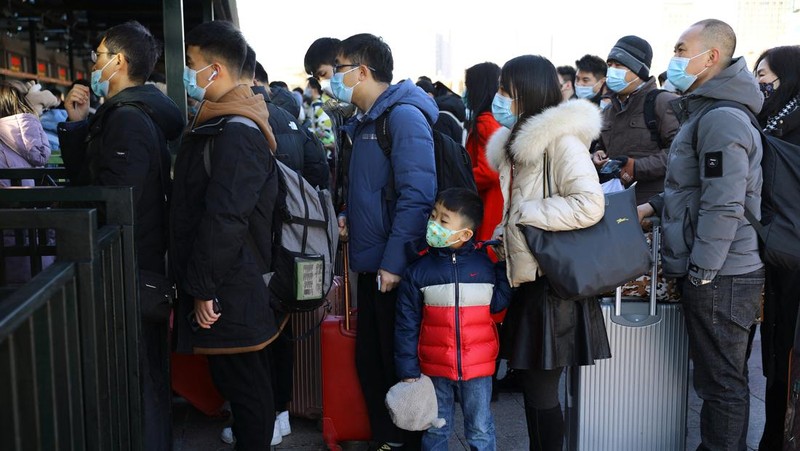 Pelancong mengenakan masker untuk melindungi diri dari COVID-19 mengantre kereta menjelang liburan Tahun Baru Imlek di sebuah stasiun di Guangzhou di Provinsi Guangdong, China selatan, Jumat (28/1/2022).  Warga China bepergian ke kampung halaman mereka untuk Tahun Baru Imlek, hari libur keluarga terbesar di negara itu , meskipun ada permintaan pemerintah untuk tetap di tempat mereka berada saat Beijing mencoba menahan wabah virus corona. (Chinatopix via AP)