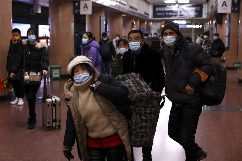 Pelancong mengenakan masker untuk melindungi diri dari COVID-19 mengantre kereta menjelang liburan Tahun Baru Imlek di sebuah stasiun di Guangzhou di Provinsi Guangdong, China selatan, Jumat (28/1/2022).  Warga China bepergian ke kampung halaman mereka untuk Tahun Baru Imlek, hari libur keluarga terbesar di negara itu , meskipun ada permintaan pemerintah untuk tetap di tempat mereka berada saat Beijing mencoba menahan wabah virus corona. (Chinatopix via AP)