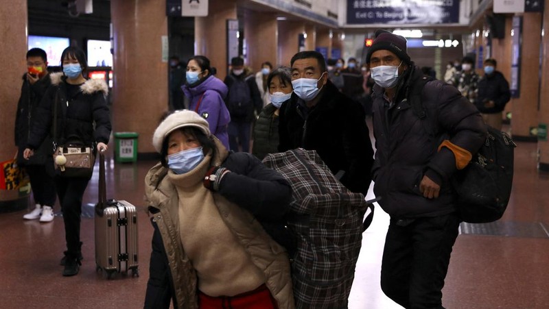 Pelancong mengenakan masker untuk melindungi diri dari COVID-19 mengantre kereta menjelang liburan Tahun Baru Imlek di sebuah stasiun di Guangzhou di Provinsi Guangdong, China selatan, Jumat (28/1/2022).  Warga China bepergian ke kampung halaman mereka untuk Tahun Baru Imlek, hari libur keluarga terbesar di negara itu , meskipun ada permintaan pemerintah untuk tetap di tempat mereka berada saat Beijing mencoba menahan wabah virus corona. (Chinatopix via AP)