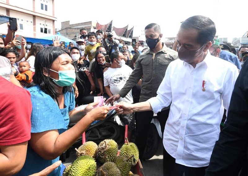 Presiden Joko Widodo membagikan bantuan langsung tunai bagi para pedagang kaki lima dan warung di Pasar Porsea, Kabupaten Toba, Provinsi Sumatera Utara, pada Rabu, 2 Februari 2022. Bantuan sebesar Rp1,2 juta per orang tersebut diharapkan bisa membantu meringankan beban para pedagang yang terdampak pandemi Covid-19. (Biro Pers Sekretariat Presiden)