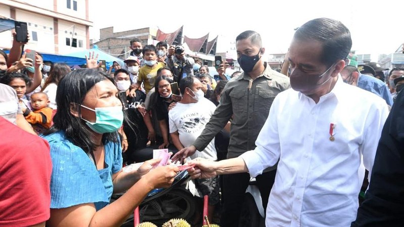 Presiden Joko Widodo membagikan bantuan langsung tunai bagi para pedagang kaki lima dan warung di Pasar Porsea, Kabupaten Toba, Provinsi Sumatera Utara, pada Rabu, 2 Februari 2022. Bantuan sebesar Rp1,2 juta per orang tersebut diharapkan bisa membantu meringankan beban para pedagang yang terdampak pandemi Covid-19. (Biro Pers Sekretariat Presiden)
