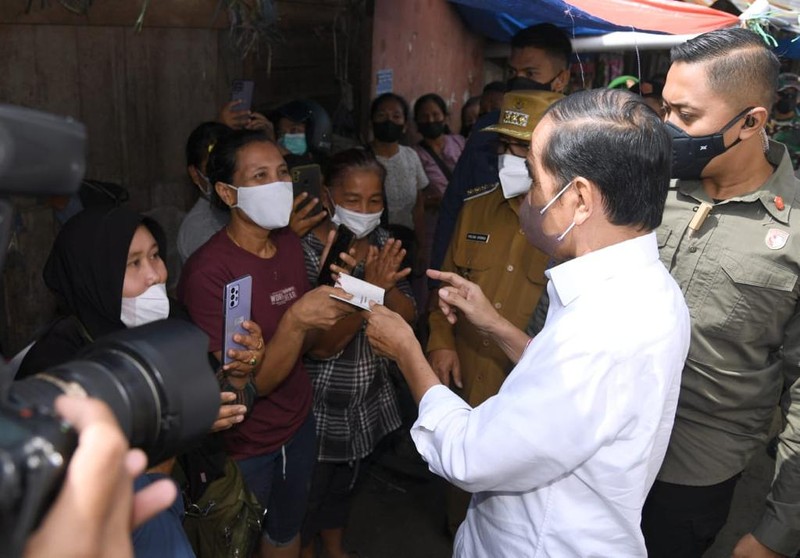 Presiden Joko Widodo membagikan bantuan langsung tunai bagi para pedagang kaki lima dan warung di Pasar Porsea, Kabupaten Toba, Provinsi Sumatera Utara, pada Rabu, 2 Februari 2022. Bantuan sebesar Rp1,2 juta per orang tersebut diharapkan bisa membantu meringankan beban para pedagang yang terdampak pandemi Covid-19. (Biro Pers Sekretariat Presiden)