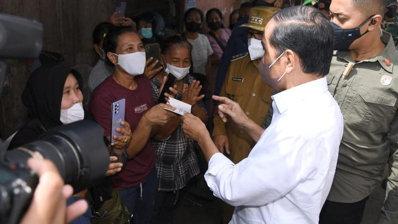 Presiden Joko Widodo membagikan bantuan langsung tunai bagi para pedagang kaki lima dan warung di Pasar Porsea, Kabupaten Toba, Provinsi Sumatera Utara, pada Rabu, 2 Februari 2022. Bantuan sebesar Rp1,2 juta per orang tersebut diharapkan bisa membantu meringankan beban para pedagang yang terdampak pandemi Covid-19. (Biro Pers Sekretariat Presiden)