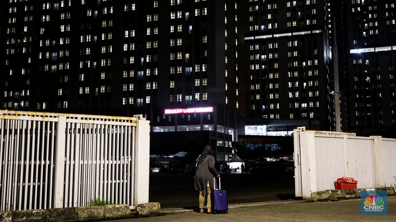 Pasien membawa koper untuk melakukan isolasi di Rumah Sakit Darurat COVID-19 (RSDC) Wisma Atlet, Kamis (3/2/2022). Pasien COVID-19 yang dirawat di Rumah Sakit Darurat COVID-19 (RSDC) Wisma Atlet terus meningkat terus. Hingga Kamis (3/2/2022) tercatat sebanyak 5.000 pasien yang dirawat. Penambahan pasien COVID-19 belakangan ini konsisten di dua ratus kasus. Per Kamis (3/2), tercatat ada 268 kasus baru yang dilaporkan. Bahkan, berdasarkan catatan grafik bulanan RSDC Wisma Atlet Kemayoran, peningkatan rawat inap pasien COVID-19 melonjak tinggi sejak akhir Desember hingga Februari 2022. (CNBC Indonesia/ Andrean Kristianto)