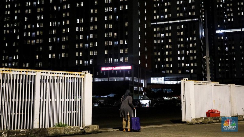 Pasien membawa koper untuk melakukan isolasi di Rumah Sakit Darurat COVID-19 (RSDC) Wisma Atlet, Kamis (3/2/2022). Pasien COVID-19 yang dirawat di Rumah Sakit Darurat COVID-19 (RSDC) Wisma Atlet terus meningkat terus. Hingga Kamis (3/2/2022) tercatat sebanyak 5.000 pasien yang dirawat. Penambahan pasien COVID-19 belakangan ini konsisten di dua ratus kasus. Per Kamis (3/2), tercatat ada 268 kasus baru yang dilaporkan. Bahkan, berdasarkan catatan grafik bulanan RSDC Wisma Atlet Kemayoran, peningkatan rawat inap pasien COVID-19 melonjak tinggi sejak akhir Desember hingga Februari 2022. (CNBC Indonesia/ Andrean Kristianto)