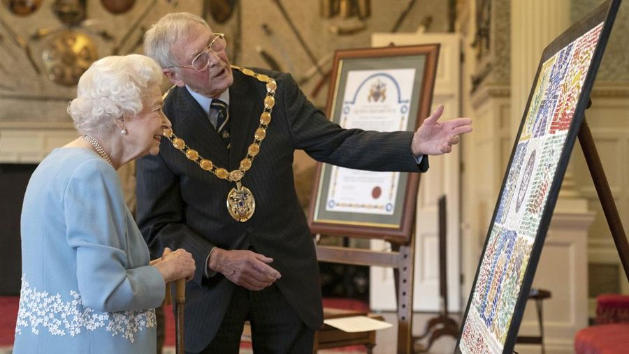 Britain's Queen Elizabeth II looks at a display of memorabilia from her Golden and Platinum Jubilees in the Oak Room at Windsor Castle, Windsor, England, in this undated but recent image that was released on Friday Feb. 4, 2022. Queen Elizabeth II will mark 70 years on the throne Sunday Feb. 6, an unprecedented reign that has made her a symbol of stability as the United Kingdom navigated an age of uncertainty. (Steve Parsons/Pool via AP)