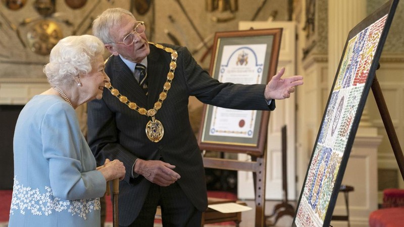 Britain's Queen Elizabeth II looks at a display of memorabilia from her Golden and Platinum Jubilees in the Oak Room at Windsor Castle, Windsor, England, in this undated but recent image that was released on Friday Feb. 4, 2022. Queen Elizabeth II will mark 70 years on the throne Sunday Feb. 6, an unprecedented reign that has made her a symbol of stability as the United Kingdom navigated an age of uncertainty. (Steve Parsons/Pool via AP)