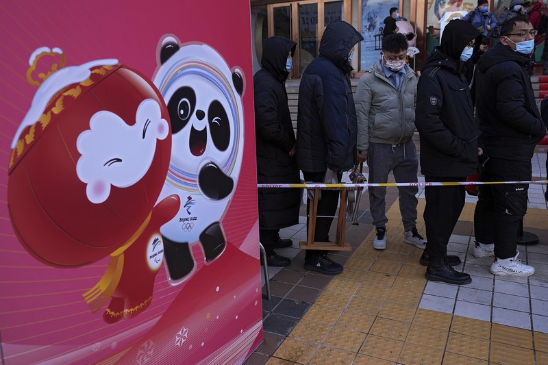 A man holds the Olympic mascot Bing Dwen Dwen doll which he purchased form a store selling 2022 Winter Olympics memorabilia in Beijing, Monday, Feb. 7, 2022. The race is on to snap up scarce 2022 Winter Olympics souvenirs. Dolls of mascot Bing Dwen Dwen, a panda in a winter coat, sold out after buyers waited in line overnight in freezing weather. (AP Photo/Andy Wong)