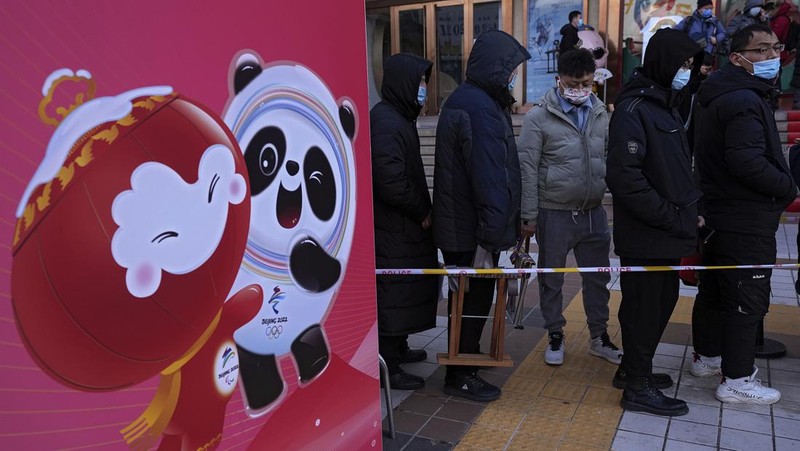 A man holds the Olympic mascot Bing Dwen Dwen doll which he purchased form a store selling 2022 Winter Olympics memorabilia in Beijing, Monday, Feb. 7, 2022. The race is on to snap up scarce 2022 Winter Olympics souvenirs. Dolls of mascot Bing Dwen Dwen, a panda in a winter coat, sold out after buyers waited in line overnight in freezing weather. (AP Photo/Andy Wong)