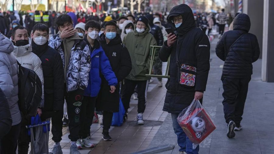 A man holds the Olympic mascot Bing Dwen Dwen doll which he purchased form a store selling 2022 Winter Olympics memorabilia in Beijing, Monday, Feb. 7, 2022. The race is on to snap up scarce 2022 Winter Olympics souvenirs. Dolls of mascot Bing Dwen Dwen, a panda in a winter coat, sold out after buyers waited in line overnight in freezing weather. (AP Photo/Andy Wong)