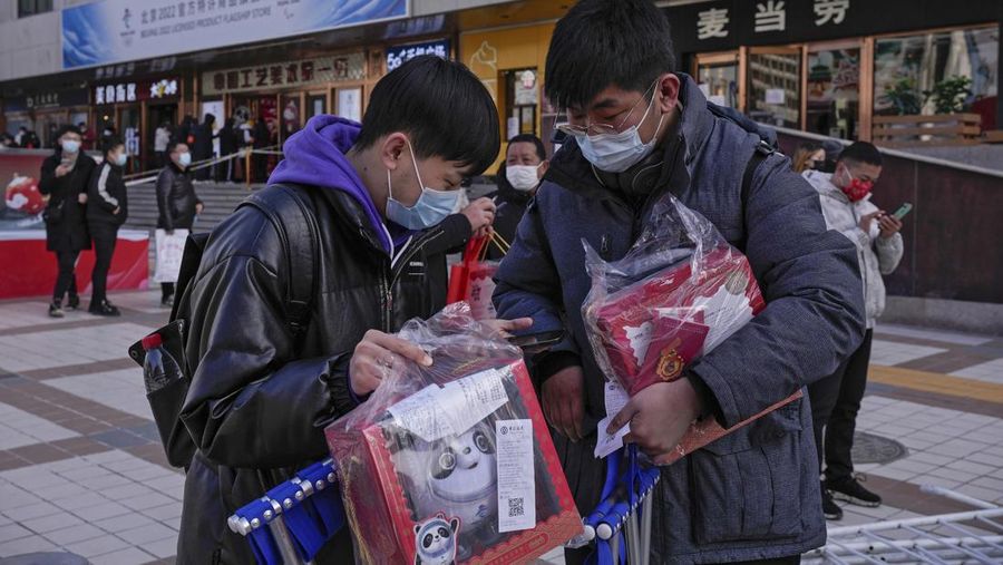A man holds the Olympic mascot Bing Dwen Dwen doll which he purchased form a store selling 2022 Winter Olympics memorabilia in Beijing, Monday, Feb. 7, 2022. The race is on to snap up scarce 2022 Winter Olympics souvenirs. Dolls of mascot Bing Dwen Dwen, a panda in a winter coat, sold out after buyers waited in line overnight in freezing weather. (AP Photo/Andy Wong)