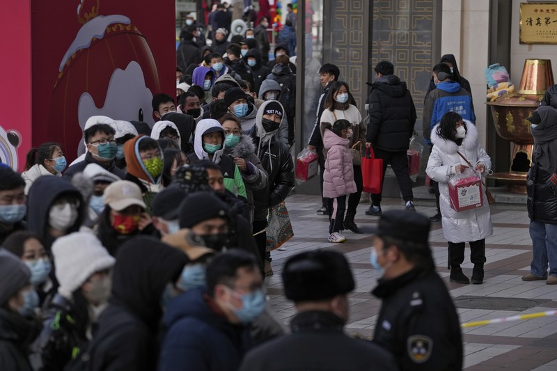 A man holds the Olympic mascot Bing Dwen Dwen doll which he purchased form a store selling 2022 Winter Olympics memorabilia in Beijing, Monday, Feb. 7, 2022. The race is on to snap up scarce 2022 Winter Olympics souvenirs. Dolls of mascot Bing Dwen Dwen, a panda in a winter coat, sold out after buyers waited in line overnight in freezing weather. (AP Photo/Andy Wong)