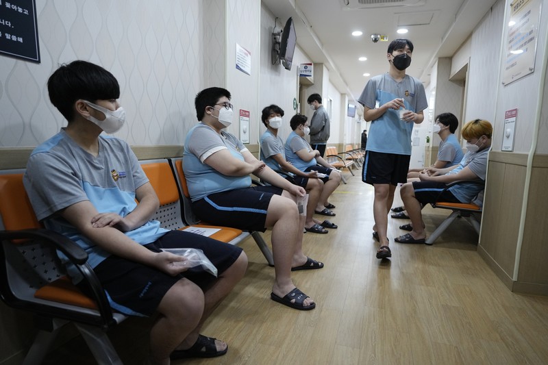 Virus Outbreak South Korea People wait for their coronavirus test at a makeshift testing site in Seoul, South Korea, Monday, Feb. 7, 2022. South Korea will no longer use GPS monitoring to enforce quarantines and will also end daily checkup calls to low-risk coronavirus patients as a fast-developing omicron surge overwhelms health and government workers. (AP Photo/Ahn Young-joon)