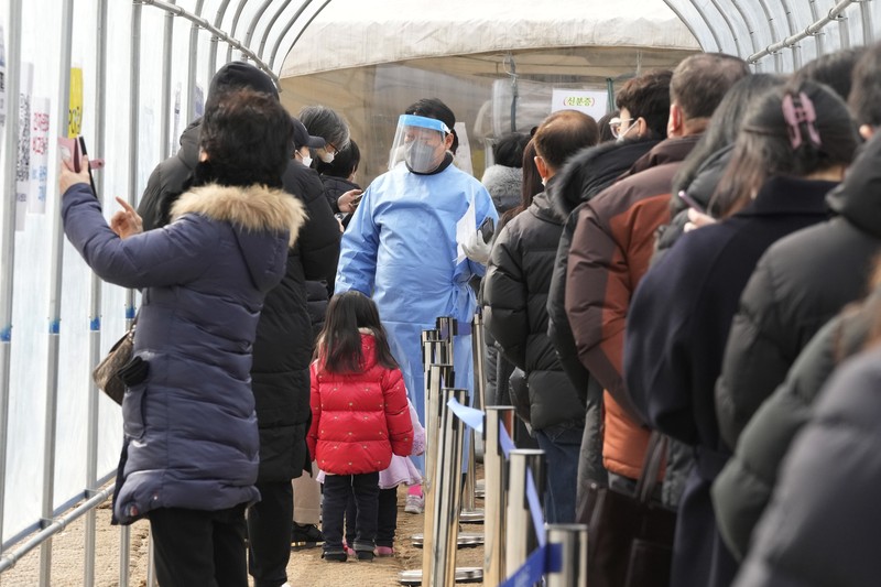 Virus Outbreak South Korea People wait for their coronavirus test at a makeshift testing site in Seoul, South Korea, Monday, Feb. 7, 2022. South Korea will no longer use GPS monitoring to enforce quarantines and will also end daily checkup calls to low-risk coronavirus patients as a fast-developing omicron surge overwhelms health and government workers. (AP Photo/Ahn Young-joon)