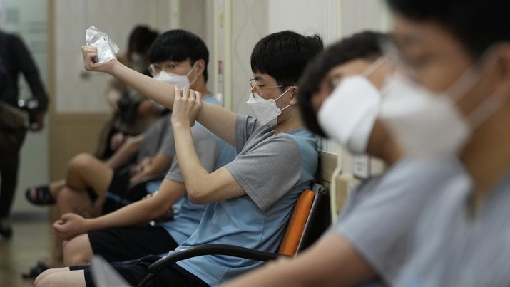 South Korean prospective soldiers wearing face masks wait to receive a medical checkup at the Seoul office of the Military Manpower Administration in Seoul, South Korea, Monday, Feb. 7, 2022. (AP Photo/Ahn Young-joon)