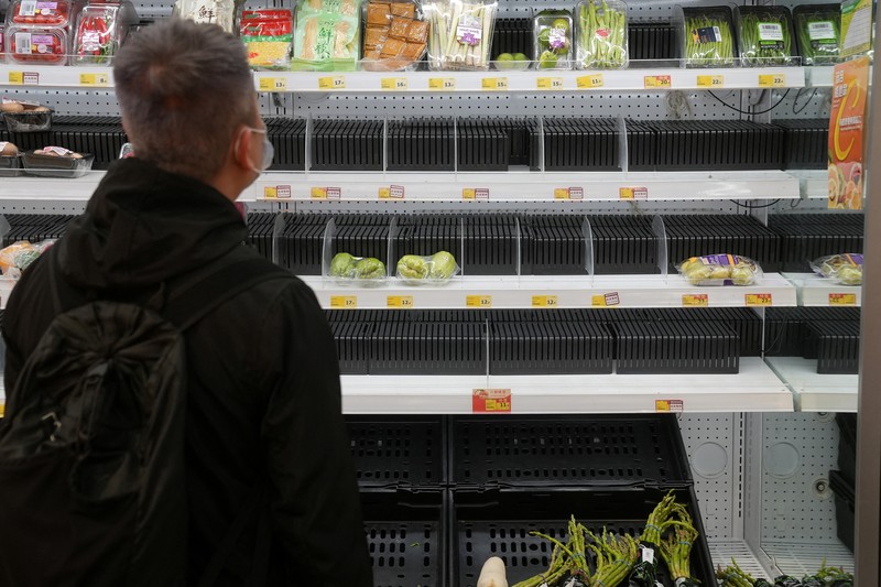 HEATLH-CORONAVIRUS/HONGKONG-FOOD Customers wearing face masks shop at a market, following the outbreak of the coronavirus disease (COVID-19), at Sha Tin district, in Hong Kong, China, February 7, 2022. REUTERS/Lam Yik