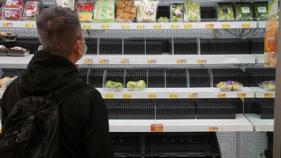 A customer wearing a face mask shops in front of partially empty shelves at a supermarket, following the outbreak of the coronavirus disease (COVID-19), at Sha Tin district, in Hong Kong, China, February 7, 2022. REUTERS/Lam Yik